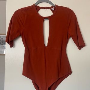 Burnt orange open back body suit with front peephole